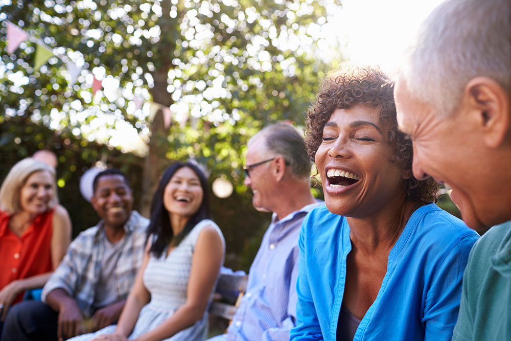 a group of friends laughing together at a picnic