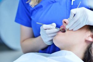 Dentist cleaning patient's mouth