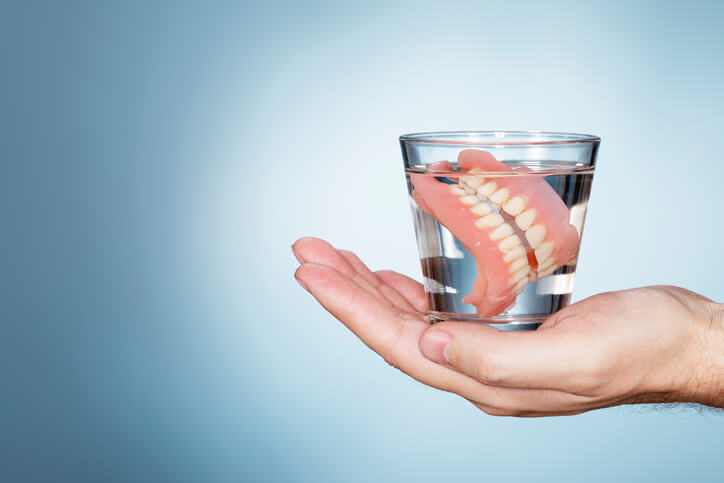 Dentures soaking in glass of water