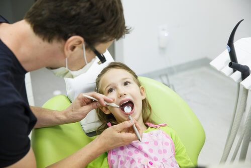 Dentist working on little girl