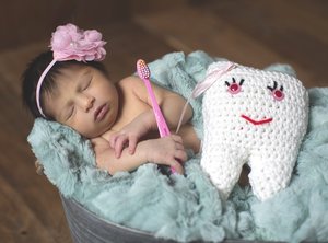 Baby sleeping with toothbrush and tooth pillow