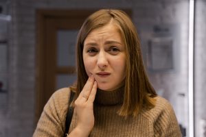Woman holding her mouth in pain