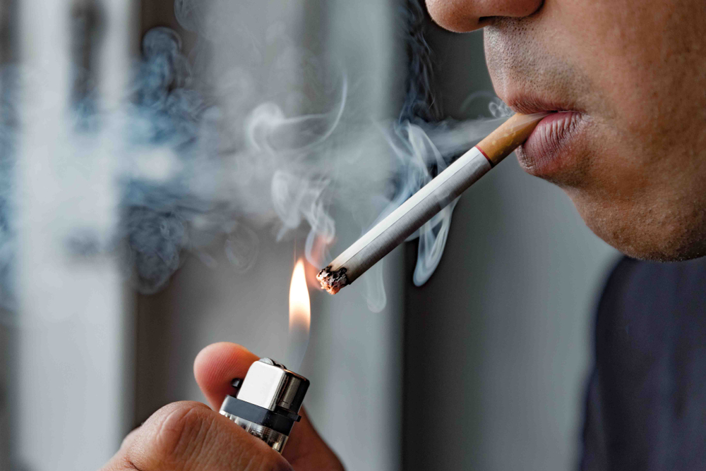 man lighting his cigarette with a lighter