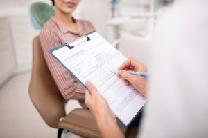 dentist going over paperwork and insurance with patient