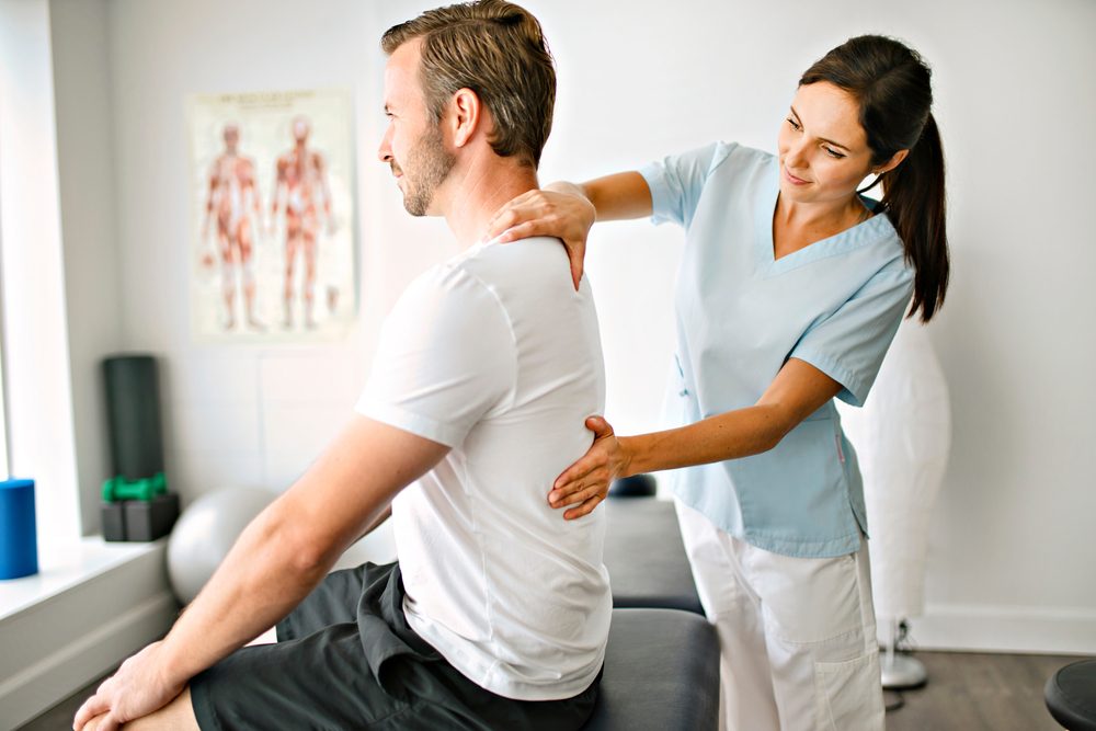 chiropractor examining a patient's back