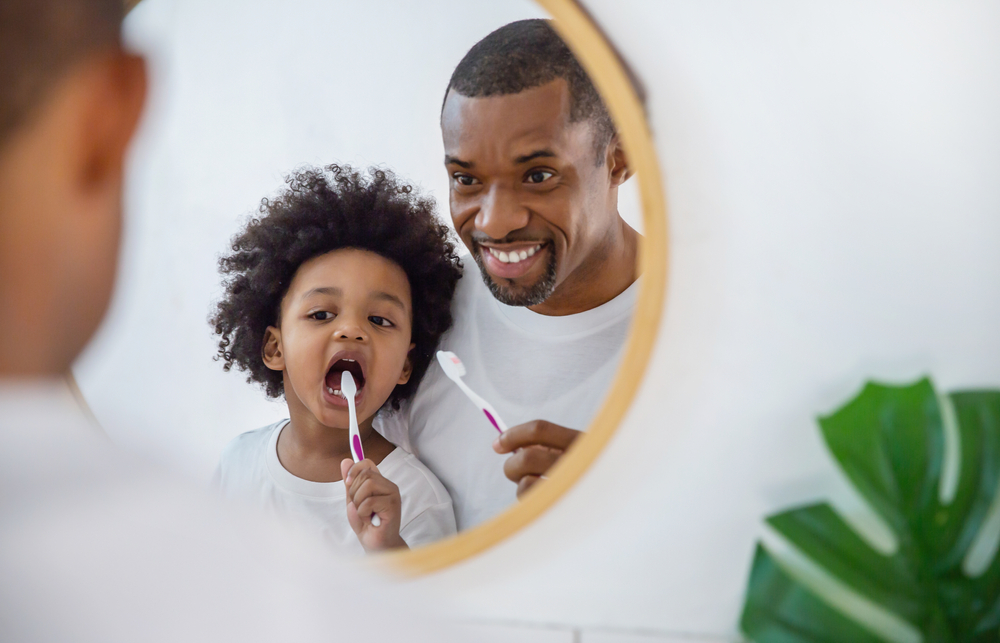 father and son brushing their teeth