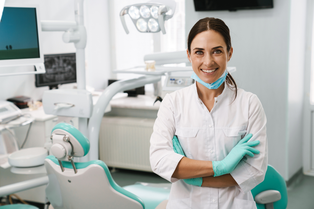 a female dentist smiling in a dental operating room.