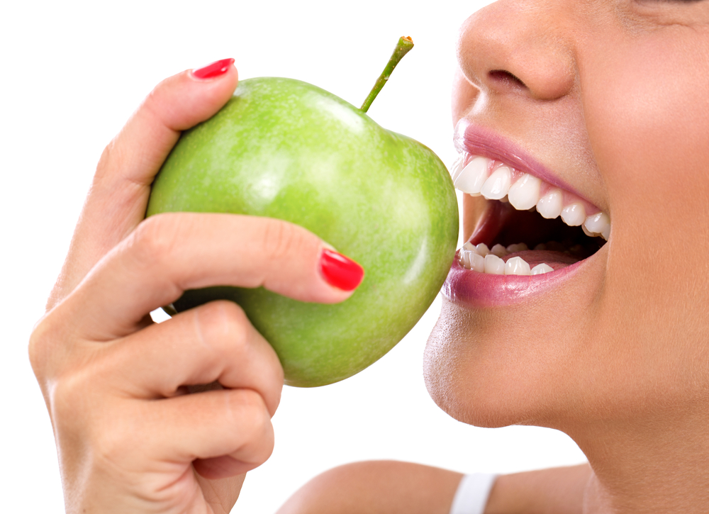 up close of a woman biting into an apple