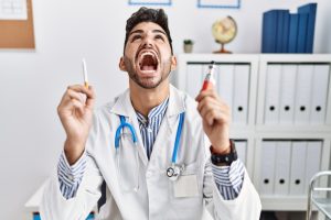 dentist holding up an e-cigarette and normal cigarette being frustrated