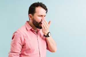 man realizing he has bad breath