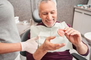 older man getting his dentures at the dentist's office